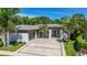 Beautiful single-story home featuring a wide driveway, modern design, and tropical landscaping at 5856 Meriwether Pl, Sarasota, FL 34232