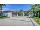 The exterior of the house shows a garage and a paved driveway with tropical landscaping around the house at 5856 Meriwether Pl, Sarasota, FL 34232