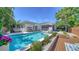 Stunning backyard featuring a sparkling pool, lush landscaping, and a cozy seating area, perfect for relaxation at 5856 Meriwether Pl, Sarasota, FL 34232