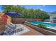 Relaxing pool deck area with lounge chairs, lush landscaping, and a privacy fence at 5856 Meriwether Pl, Sarasota, FL 34232
