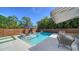 Outdoor pool area with lounge chairs, mature landscaping, and an awning covered seating area at 5856 Meriwether Pl, Sarasota, FL 34232
