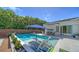 Beautiful backyard pool with lounge chairs, lush tropical landscaping, and an awning covered seating area at 5856 Meriwether Pl, Sarasota, FL 34232