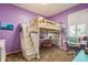 Bedroom showcasing a stylish loft bed, desk area, and charming purple walls at 622 147Th E St, Bradenton, FL 34212