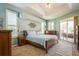 Tranquil main bedroom suite featuring a king bed, tray ceiling, private access to outdoor patio, and ensuite at 622 147Th E St, Bradenton, FL 34212