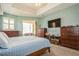 Well-lit main bedroom with blue accents, carpeted floors, tray ceilings, and a private outdoor view at 622 147Th E St, Bradenton, FL 34212