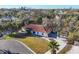 Charming home with a red tile roof surrounded by lush greenery and mature trees viewed from above at 670 Venice Ln, Sarasota, FL 34242