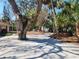 Spacious driveway surrounded by lush greenery and tropical trees, providing shade and privacy at 670 Venice Ln, Sarasota, FL 34242