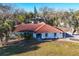 Charming single-story home with a terra cotta tile roof surrounded by lush landscaping at 670 Venice Ln, Sarasota, FL 34242
