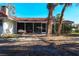 A view of the home's screened in porch with a red tile roof and lush landscaping at 670 Venice Ln, Sarasota, FL 34242