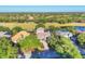 Expansive aerial view of a beautiful home nestled on a golf course with lush greenery and a serene lake backdrop at 7257 Greystone St, Lakewood Ranch, FL 34202
