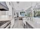 Open concept kitchen with stainless steel appliances, marble countertops, and an island with a farmhouse sink at 7257 Greystone St, Lakewood Ranch, FL 34202