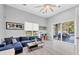 Cozy living room with a blue sectional, bright natural light, and a view of the backyard at 7257 Greystone St, Lakewood Ranch, FL 34202