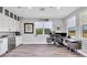 Well-lit home office with built-in cabinets, granite countertops, stainless steel appliances, and gray wood flooring at 7257 Greystone St, Lakewood Ranch, FL 34202