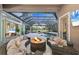 Inviting outdoor area featuring a cozy seating area with a fire pit and screened-in pool at 7257 Greystone St, Lakewood Ranch, FL 34202