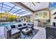 Beautiful outdoor living space with a screened-in pool, seating, and a built-in kitchen area at 7257 Greystone St, Lakewood Ranch, FL 34202