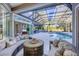 Luxury outdoor space with an enclosed pool, lounge furniture, and a view of the lush backyard at 7257 Greystone St, Lakewood Ranch, FL 34202