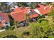 Aerial view of property showcasing lush landscaping and a beautiful red tile roof at 7261 Villa D Este Dr, Sarasota, FL 34238