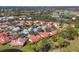 Aerial view of community showcasing a neighborhood with mature trees, landscaping, and golf course at 7261 Villa D Este Dr, Sarasota, FL 34238