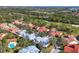 Stunning aerial view of community showcasing golf course, lush trees, and beautiful red-tiled roofs at 7261 Villa D Este Dr, Sarasota, FL 34238