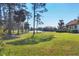 Expansive backyard with mature trees overlooking a tranquil lake and golf course at 7261 Villa D Este Dr, Sarasota, FL 34238