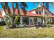 Large backyard with a patio, plants and a home with a red tiled roof at 7261 Villa D Este Dr, Sarasota, FL 34238