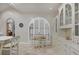 Elegant kitchen nook with white chairs, round table, and custom arched window shutters at 7261 Villa D Este Dr, Sarasota, FL 34238