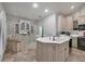 Spacious kitchen with white cabinetry, a large island with seating, and travertine flooring at 7261 Villa D Este Dr, Sarasota, FL 34238