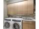 Bright laundry room featuring modern washer and dryer, cabinetry, and stainless steel sink at 7261 Villa D Este Dr, Sarasota, FL 34238