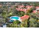 Beautiful view of pool and spa surrounded by lounge chairs and community residences with red tiled roofs at 7261 Villa D Este Dr, Sarasota, FL 34238
