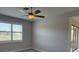 Bright bedroom with large window, ceiling fan, and neutral color palette at 7608 Registrar Way, Sarasota, FL 34243
