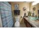 Bathroom featuring a vanity with a clear glass bowl sink and a shower with a blue-striped curtain at 9100 Dr Martin Luther King Jr N St # 205, St Petersburg, FL 33702