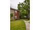 Close-up of townhome exterior with brick accents, well-maintained lawn, mature landscaping, and a walking path at 9100 Dr Martin Luther King Jr N St # 205, St Petersburg, FL 33702