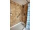 Tiled shower with a grab bar and a shower head, complemented by a blue and white striped shower curtain at 9100 Dr Martin Luther King Jr N St # 205, St Petersburg, FL 33702