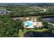 Overhead view of a community pool, playground, tennis courts, and lake at 1017 Siberian Glen, Bradenton, FL 34212