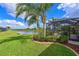 Landscaped backyard with a palm tree overlooking the pond, screen enclosed pool, and the home's patio at 1017 Siberian Glen, Bradenton, FL 34212