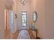 Bright foyer featuring wood-look tile flooring, decorative mirror, glass top console table, and stylish light fixture at 1017 Siberian Glen, Bradenton, FL 34212