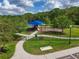 Community playground with shade structure surrounded by trees and walking paths at 1017 Siberian Glen, Bradenton, FL 34212