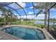Resort-style screened-in pool area with waterfall feature and lake views at 1017 Siberian Glen, Bradenton, FL 34212