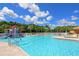 Community pool with splash features, seating and palm trees at 1017 Siberian Glen, Bradenton, FL 34212