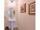 Bathroom featuring a pedestal sink, decorative mirror, and tasteful wall art at 1017 Siberian Glen, Bradenton, FL 34212