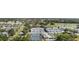 Aerial view showcasing townhomes, a community pool, tennis courts, and lush landscaping at 1041 Capri Isles Blvd # 232, Venice, FL 34292