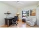Cozy bedroom with light green walls and wood floors, featuring a desk and white chair at 1041 Capri Isles Blvd # 232, Venice, FL 34292