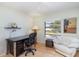 Cozy bedroom with light green walls and wood floors, featuring a desk and white chair at 1041 Capri Isles Blvd # 232, Venice, FL 34292