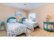 Charming bedroom featuring matching twin beds, coastal decor, hardwood floors, and natural light at 1041 Capri Isles Blvd # 232, Venice, FL 34292