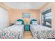 Bright bedroom with twin beds, featuring coastal decor, hardwood floors, and natural lighting at 1041 Capri Isles Blvd # 232, Venice, FL 34292