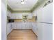 Well-lit kitchen with white cabinets, appliances, and neutral countertops at 1041 Capri Isles Blvd # 232, Venice, FL 34292