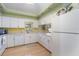 Bright kitchen featuring white cabinetry, light wood flooring, and sunny yellow backsplash at 1041 Capri Isles Blvd # 232, Venice, FL 34292