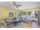 Bright living room featuring a comfortable sectional sofa, fan, and large windows at 1041 Capri Isles Blvd # 232, Venice, FL 34292