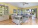 Bright living room featuring a comfortable sectional sofa, fan, and large windows at 1041 Capri Isles Blvd # 232, Venice, FL 34292