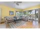 Bright living room featuring a comfortable sectional sofa, fan, and large windows at 1041 Capri Isles Blvd # 232, Venice, FL 34292